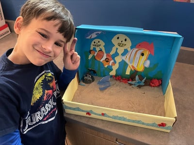 One of Ms. Walsh's students shows off his space for his desk for pets to live in.