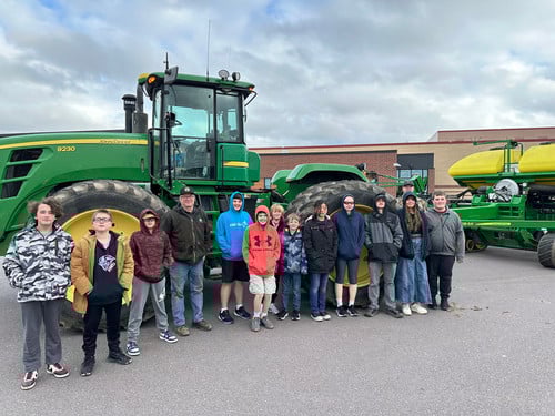 iLEAD students pose in front of a tractor brought to school by a local farmer.