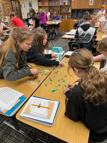 Students huddle together to solve a math problem.