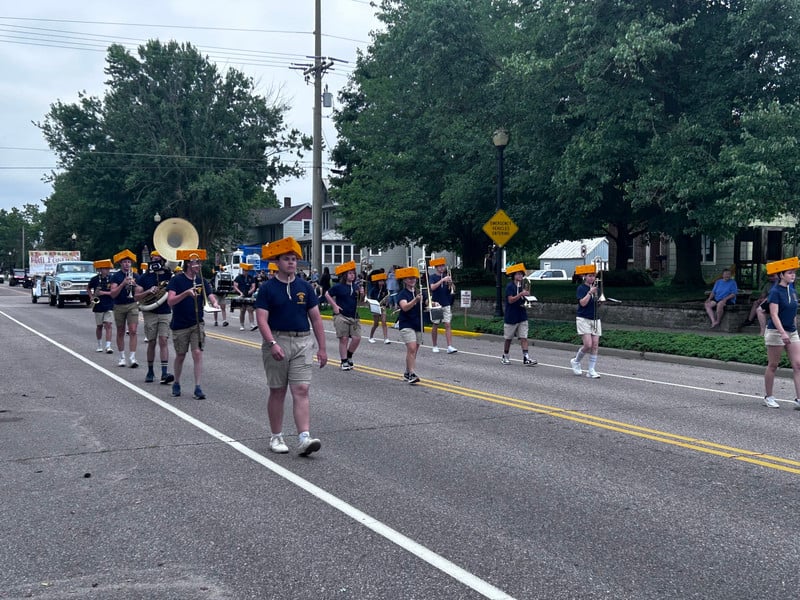 MHS Band marches down the street with their instruments.
