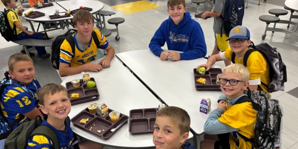 Students with food sit in a circle.