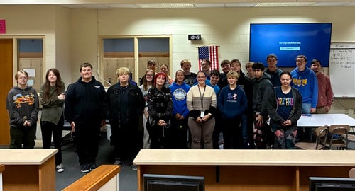 Students stand with Andrea Thompson after a presentation.