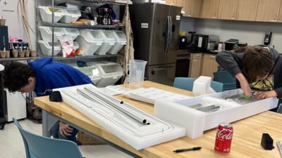 Students working on building shelves for a STEM project.