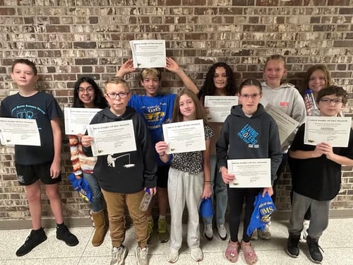 Students show off their Student of the Month certificates.