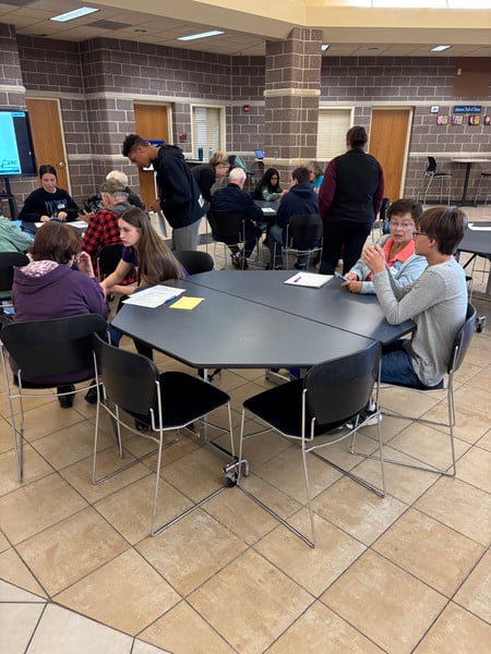 Students helping adults with their phones or mobile devices.