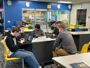 Students working collaboratively on laptops at a shared desk in a classroom at Lemonweir Academy.