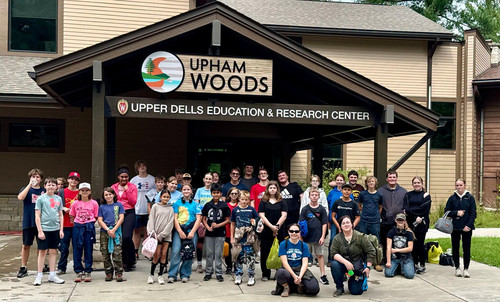 iLEAD class students posing together under the Upham Woods Education & Research Center sign.